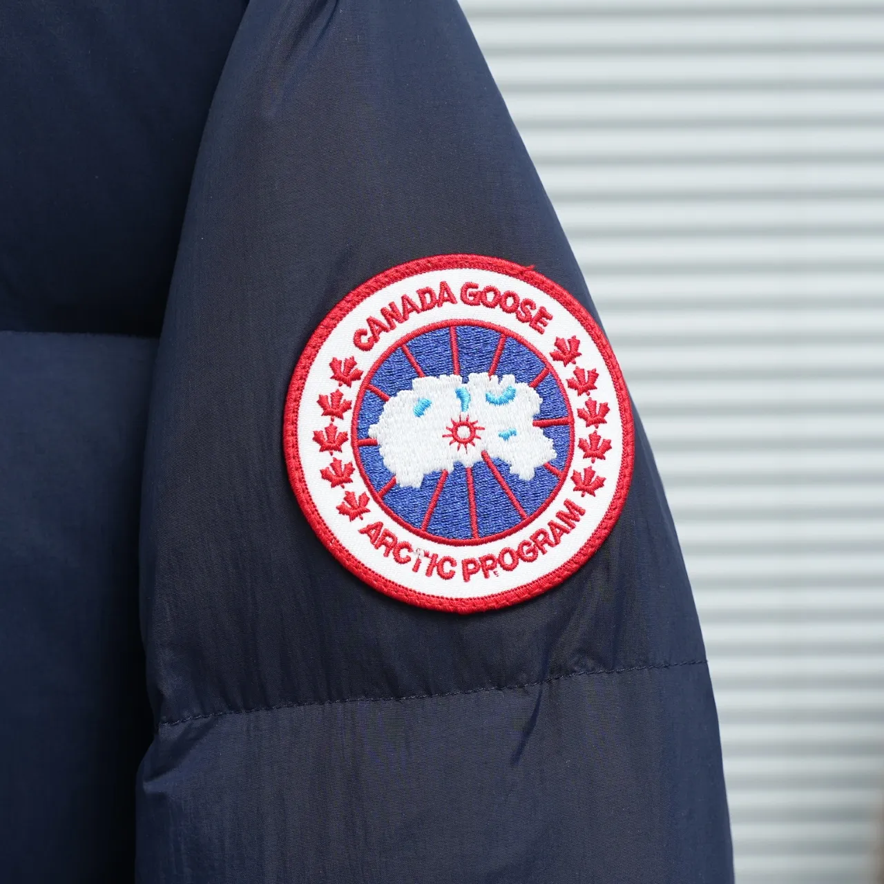P940 Canada Goose Lawrence Down Jacket The Lawrence Down Jacket provides essential protection for everyday adventures and is made from sustainable Enduraluxe fabric with a durable soft touch. It features a quilted body, an adjustable down hood and a longer hem. Adjustable, down-filled, communicated hood. Two-way center front zipper increases range of motion and ventilation. The chin-protecting suede knit stand-up collar is soft and extra-comfortable. Inset rib-knit cuffs for added comfort and locked in heat. CORDURAD piping at the cuffs hem and reflective double-stripe grip tape at the back. Internal shoulder strap Color: black with red label black with black label azure blue Size: XS-2XL